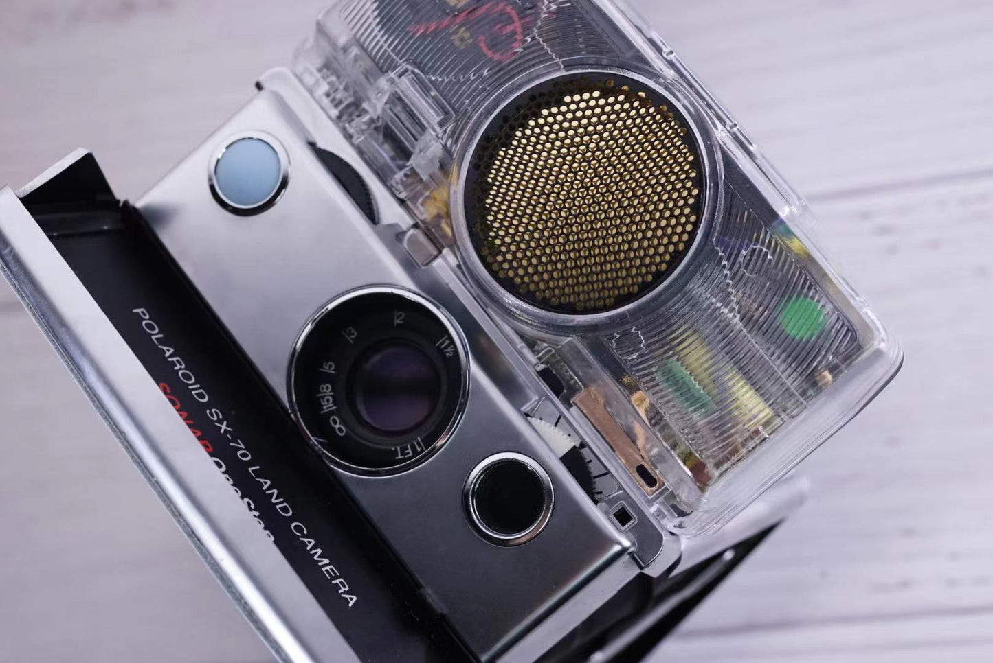 Polaroid SX70 SONAR Transparent vision ISO600 BABY BLUE Shutter button